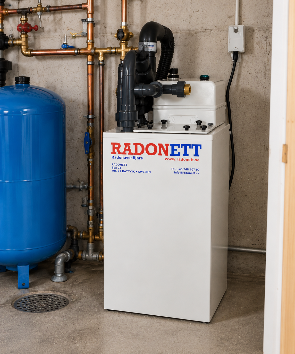 Radonavskiljare installerad i källare bredvid hydrofor och kopparrör